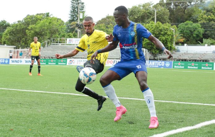 Carlos Rossel de Moca FC batalla en busca de la peltoa con Walny Bien-aimé de Atlántico FC