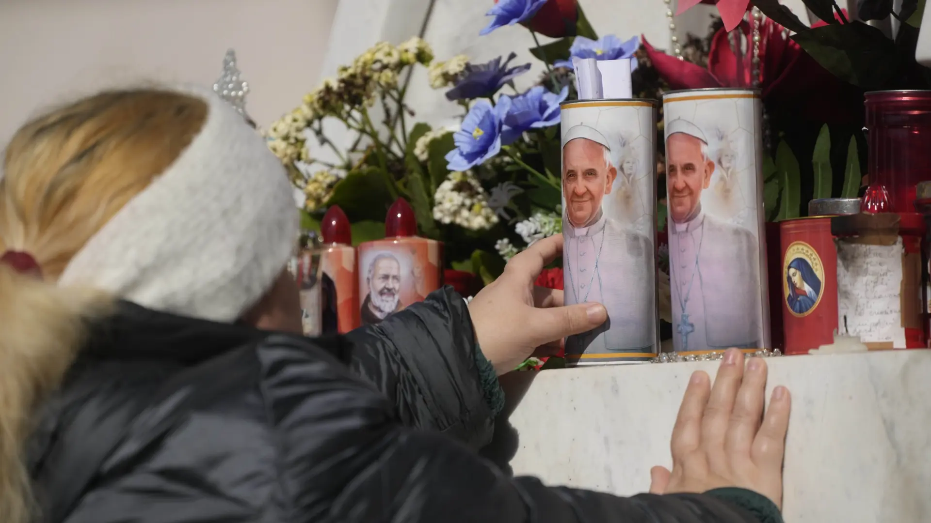una-mujer-lleva-velas-al-altar-en-honor-al-papa-francisco-en-el-hospital-gemelli.jpeg