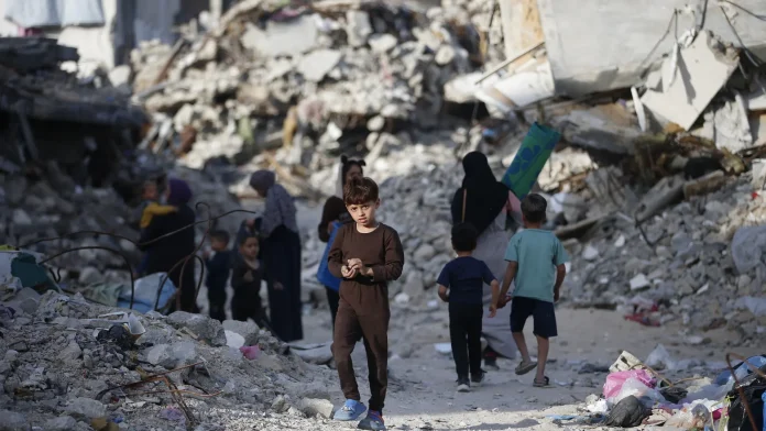 palestinos-caminan-sobre-los-escombros-provocados-por-los-ataques-israelies-en-yabalia-en-el-norte-d.webp