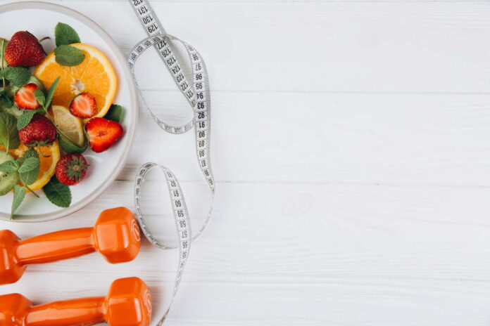 diet-plan-menu-or-program-tape-measure-water-dumbbells-and-diet-food-of-fresh-fruits-on-white.jpg