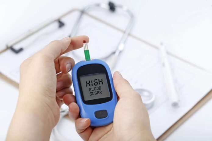 hand-holding-blood-glucose-meter-measuring-blood-sugar-background-is-stethoscope-chart-file-1500x100.jpeg